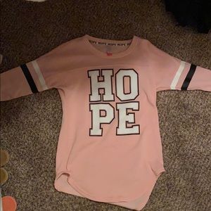 A pink shirt that says hope on it.